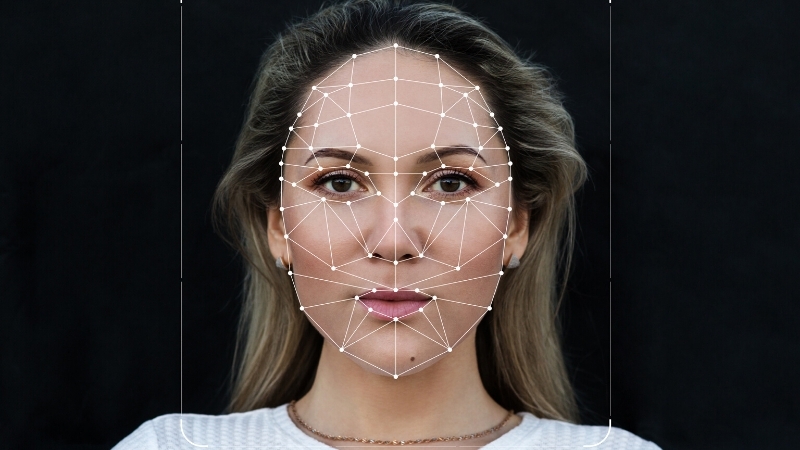 Facial recognition technology maps a woman’s features, showcasing synthetic media’s potential to enhance workplace communication.