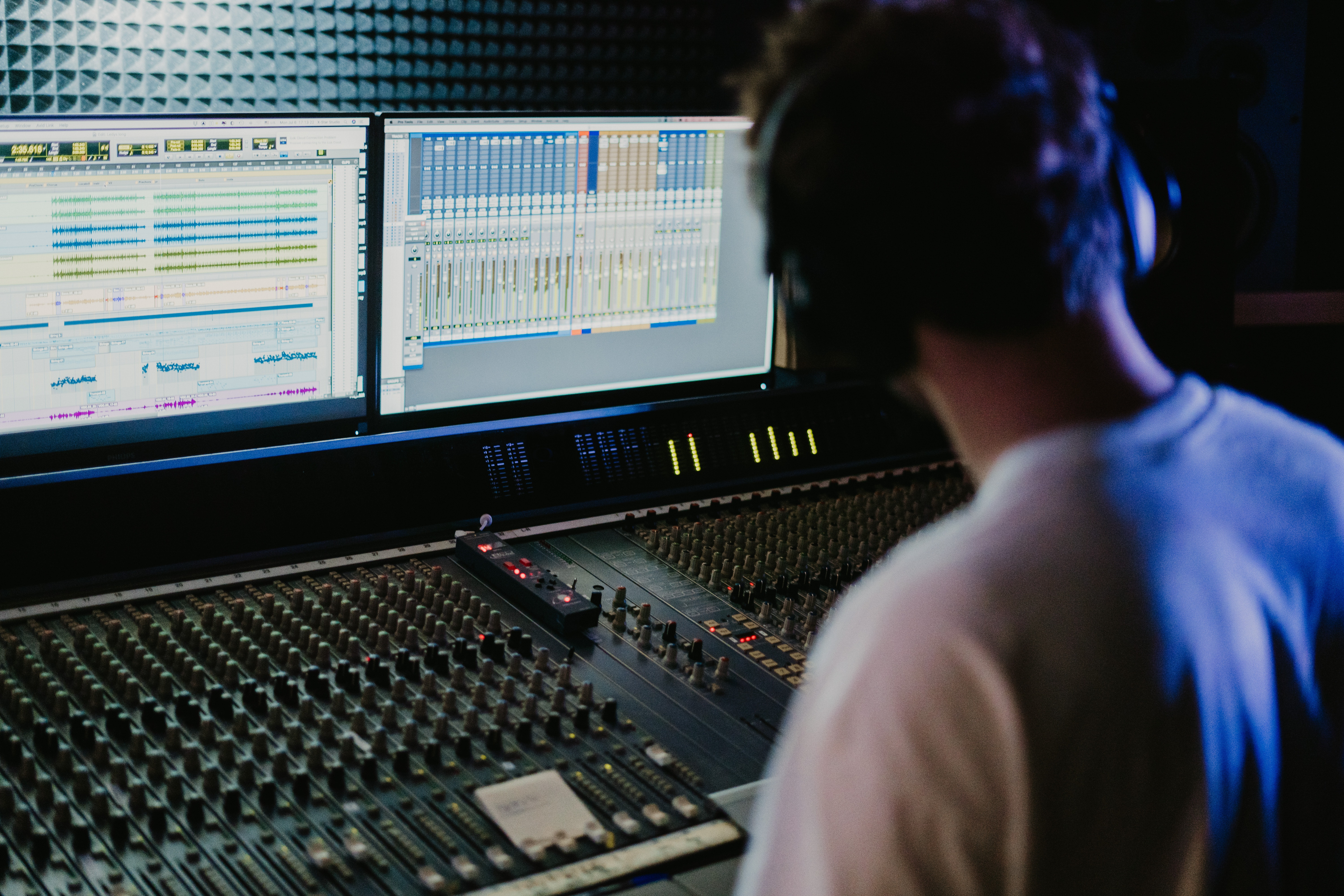 Audio engineer working on sound mixing desk with digital audio workstation software, adjusting synthetic speech tracks
