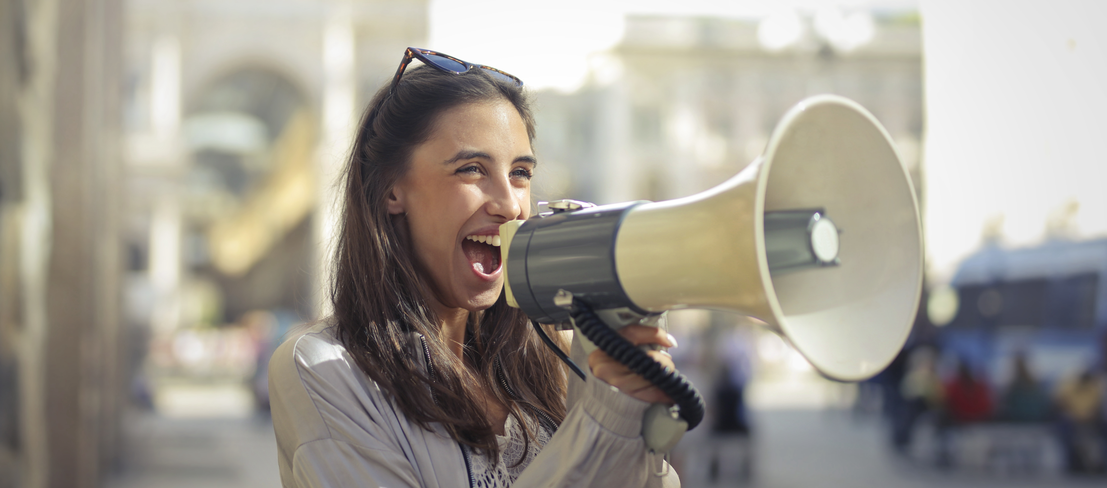 An advertiser joyfully shouts into a megaphone, symbolizing the dynamic impact of AI-enhanced audio advertising in reaching audiences.