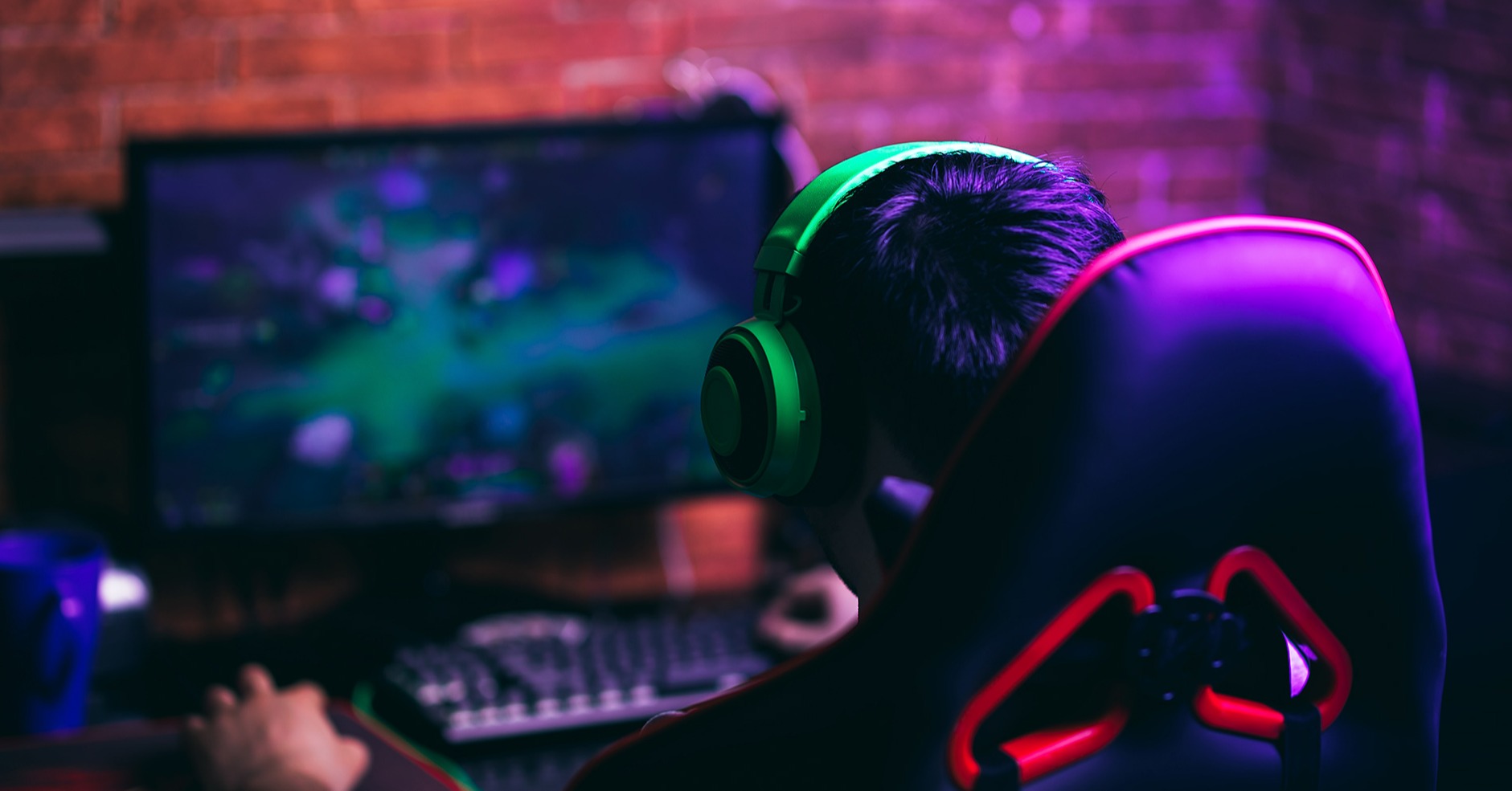Gamer wearing green headphones focused on playing a video game, illustrating the integration of AI voice synthesis technology in indie game development