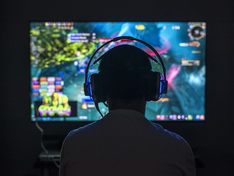 A gamer with headphones immersed in a vibrant video game, symbolic of the advanced voice synthesis technology transforming gaming experiences
